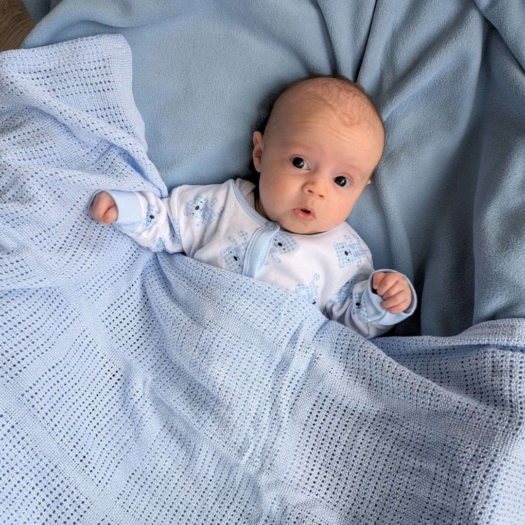 Baby under a blue cellular blanket.