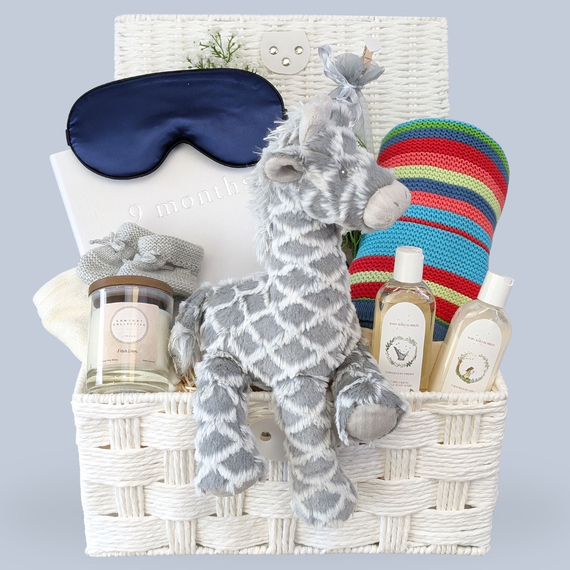 Mum to be hamper with gifts including baby nine month journal, chocolates, pamper skincare,& candle in a basket.