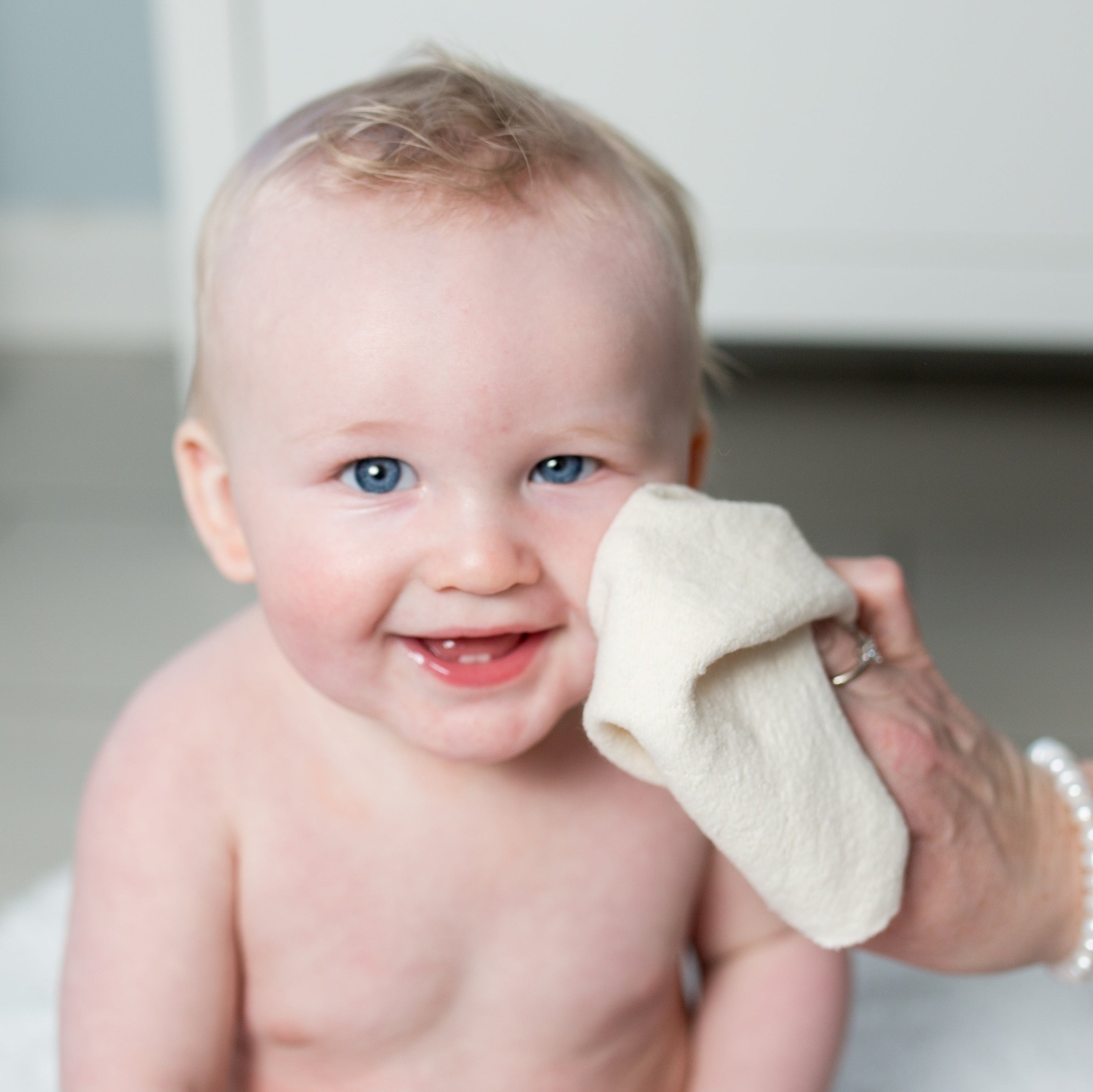 baby being washed with a facecloth