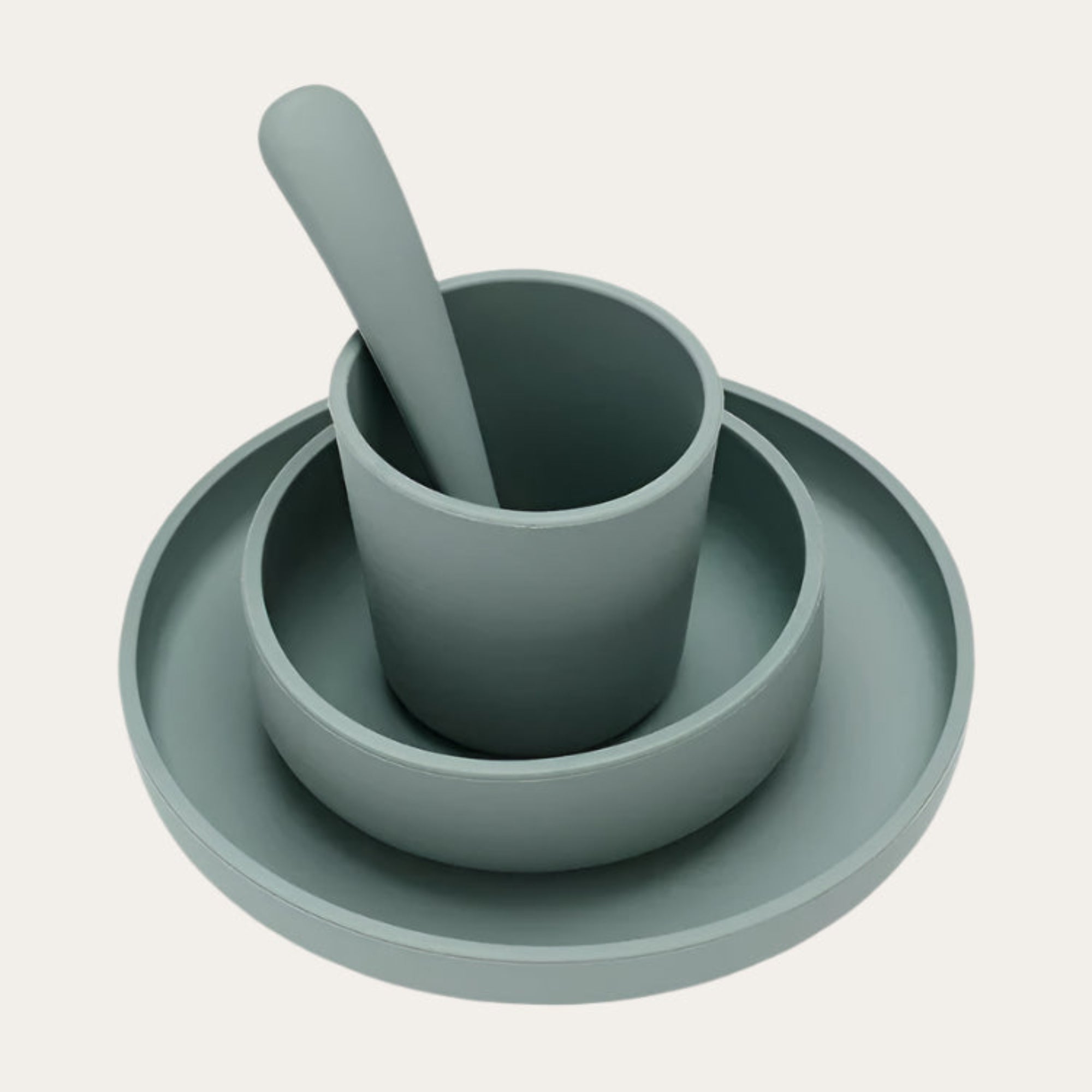 Children’s Silicone Tableware Set in Ash Green, including a suction plate, bowl, spoon, and cup.