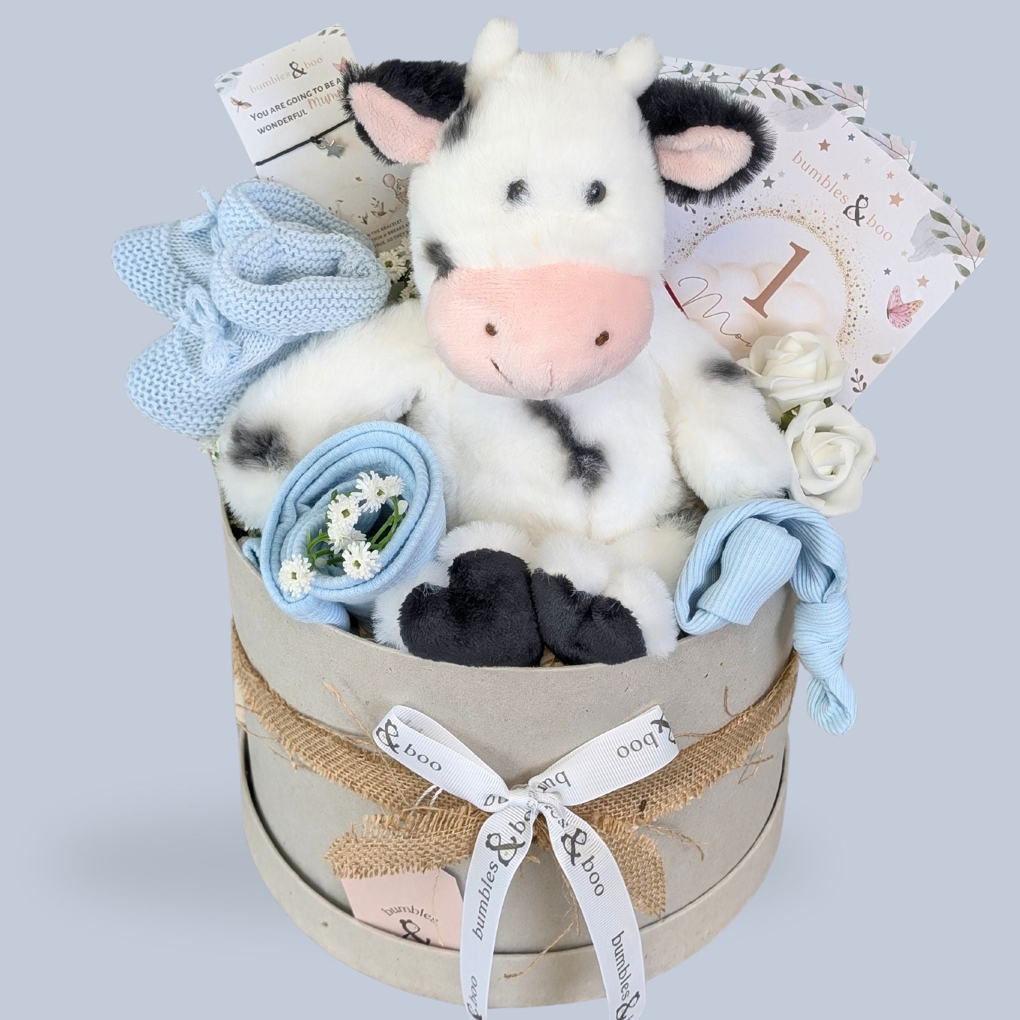 baby boy gifts hamper box with soft cuddly cow, milestone cards and bracelet for mum in a hat box.