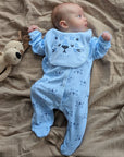 Baby wearing a blue baby boy clothing set with tiger theme, lying down.