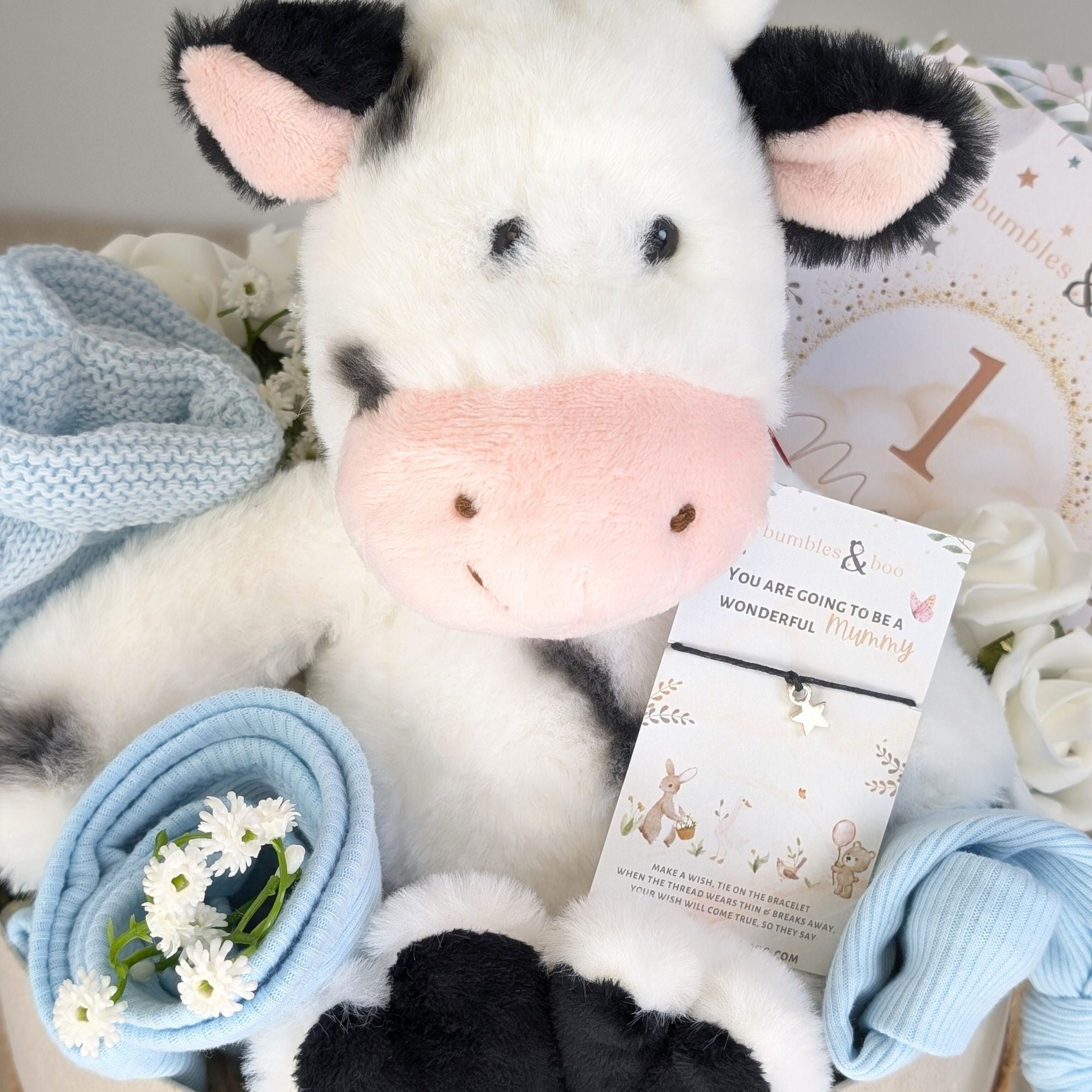 baby boy gifts hamper box with soft cuddly cow, baby booties, baby hat, baby bib, baby booties, milestone cards and bracelet for mum.