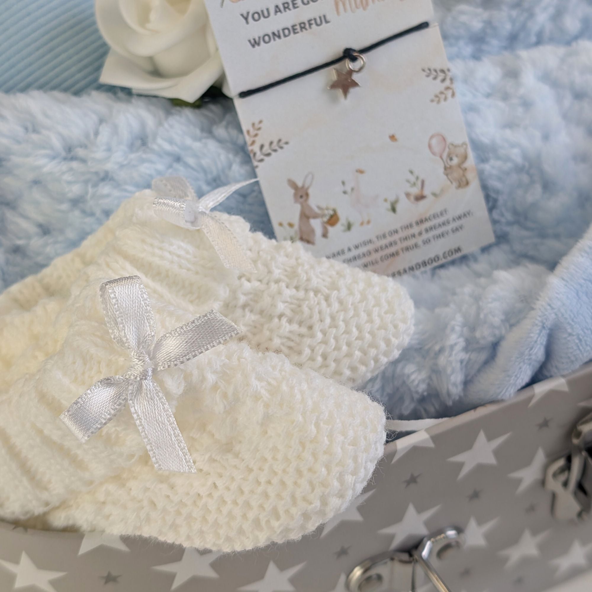 White baby booties at the front of the hamper.