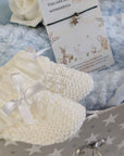 White baby booties at the front of the hamper.