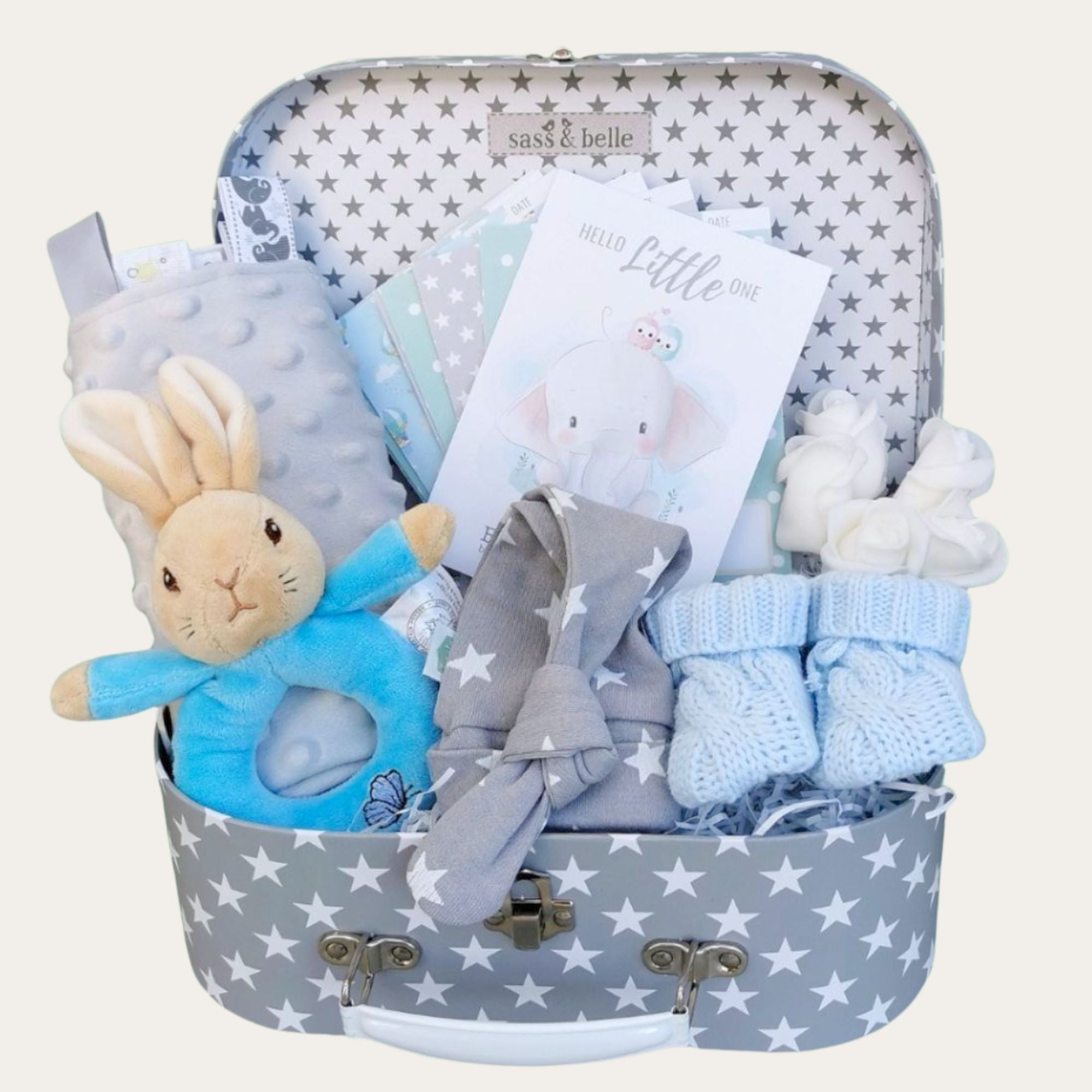 Baby boy gifts in a hamper with blue Peter Rabbit ring rattle.