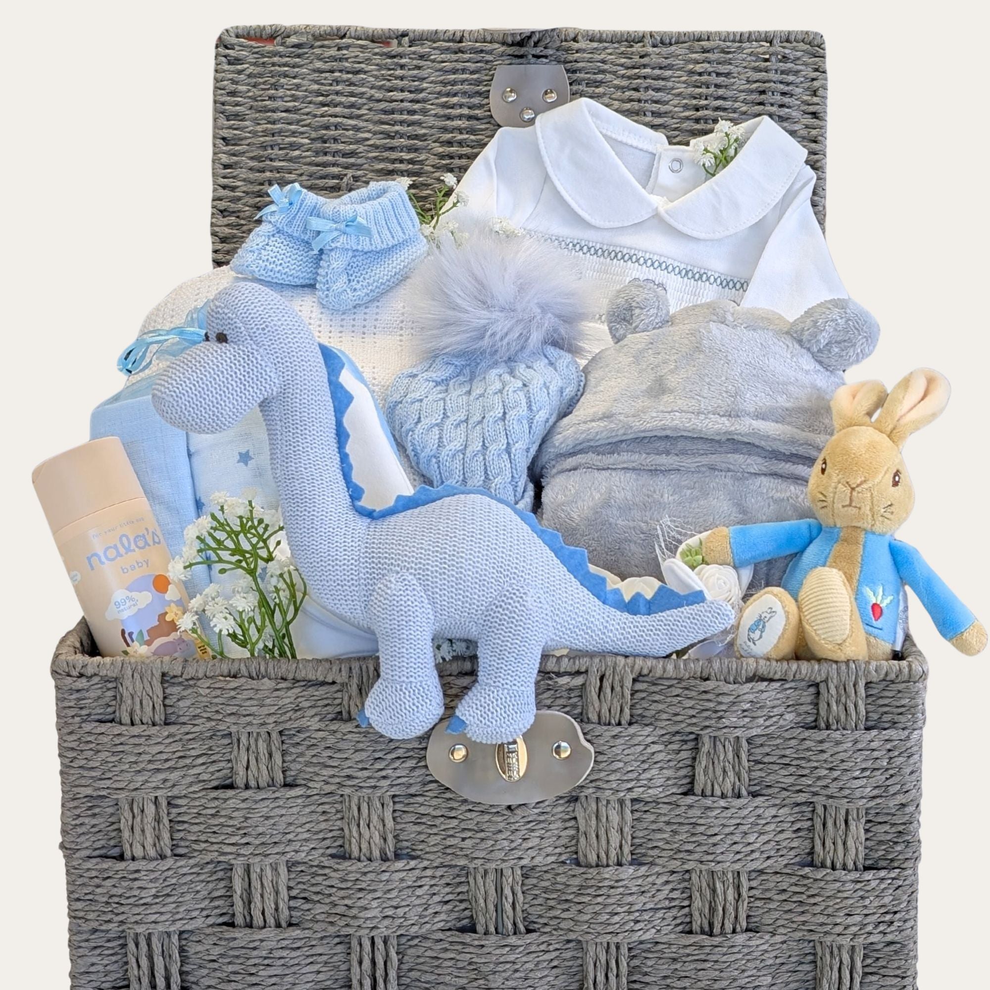 Baby boy gifts hamper basket with presents including dressing gown, baby clothes, muslin squares, blanket and newborn toys.