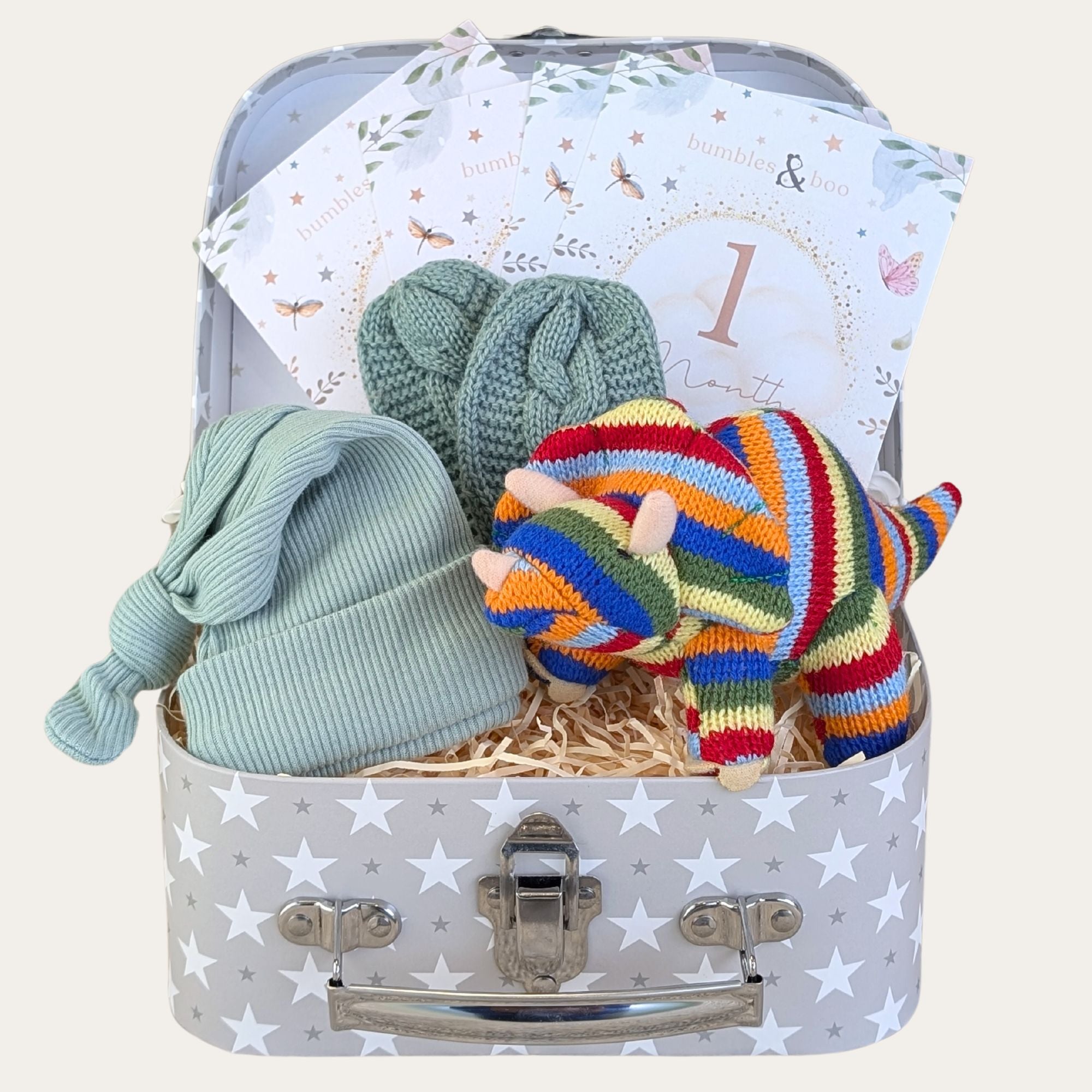 Baby boy gifts hamper trunk with colourful dinosaur, green hat & mittens and milestone cards.