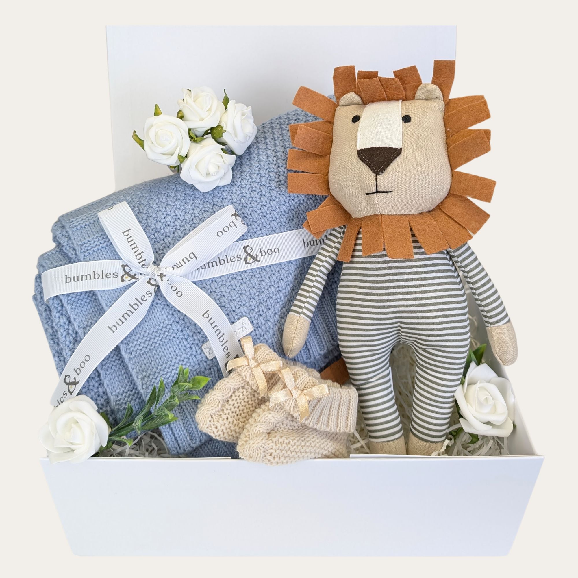 Baby boy hamper in a white gifts box with blue blanket and lion soft toy.