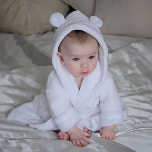 Baby dressing gown white fleece, modelled by a baby.