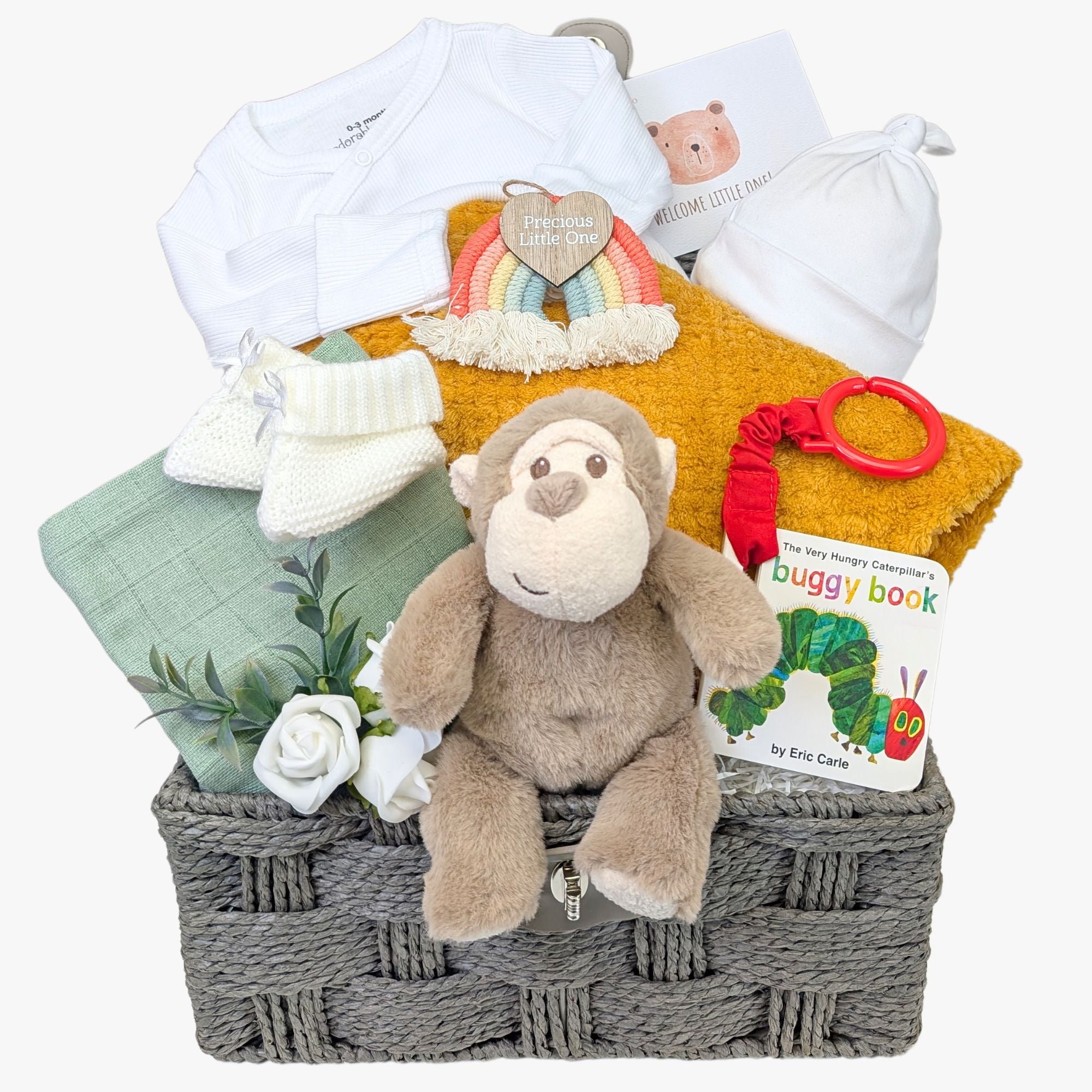 Baby gift hamper with a recycled monkey toy, breathable blanket, *Very Hungry Caterpillar* buggy book for sensory play, muslin square, knit booties, cotton hat, recycled sleepsuit, nursery plaque, and greetings card.