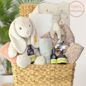 baby girl gifts basket with organic sleepsuit, organic, towel, organic muslin squares and a large steiff bunny.