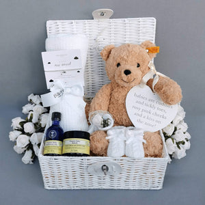 new baby gifts in a white hamper basket.