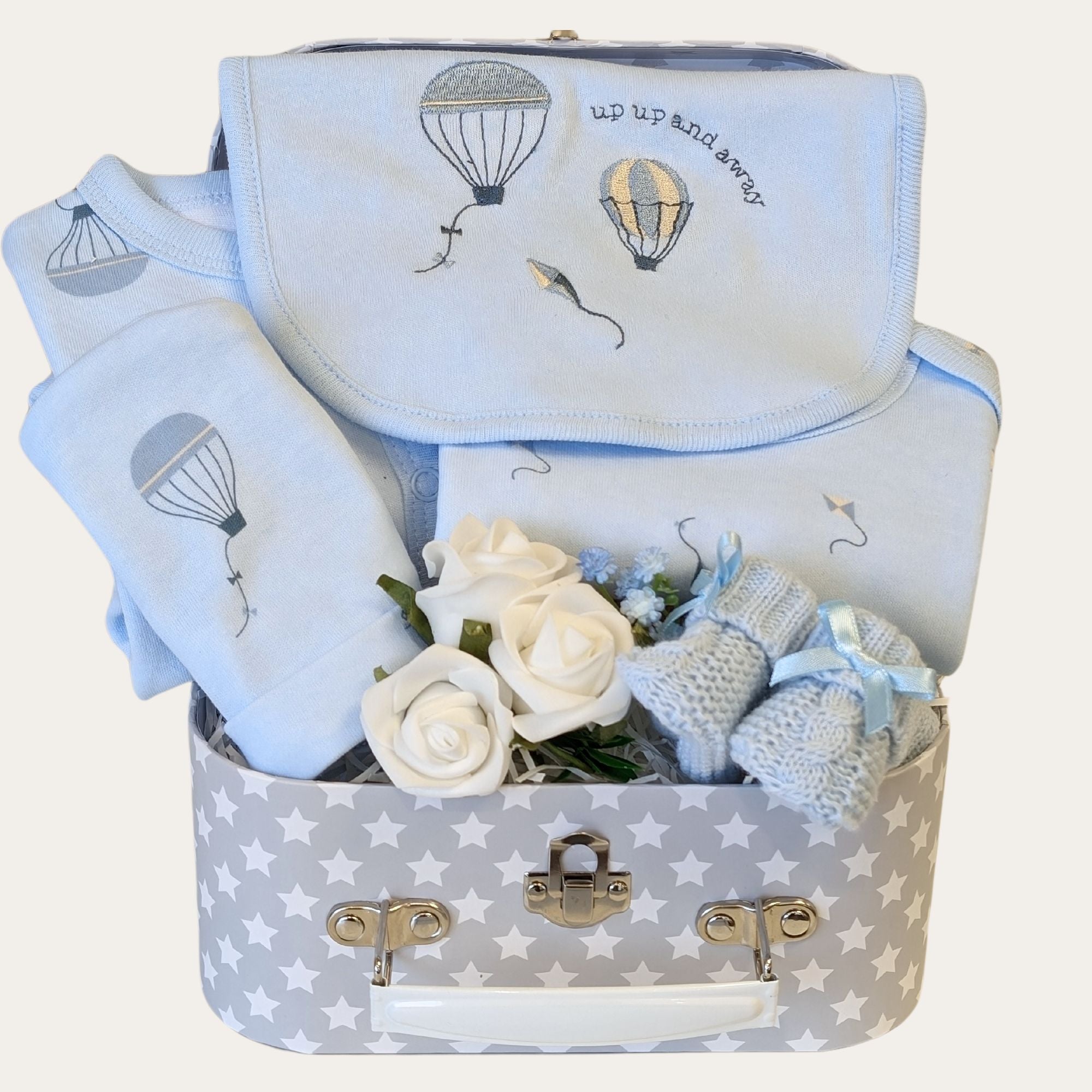 Baby boy gifts hamper with blue clothing set and blue knit booties.