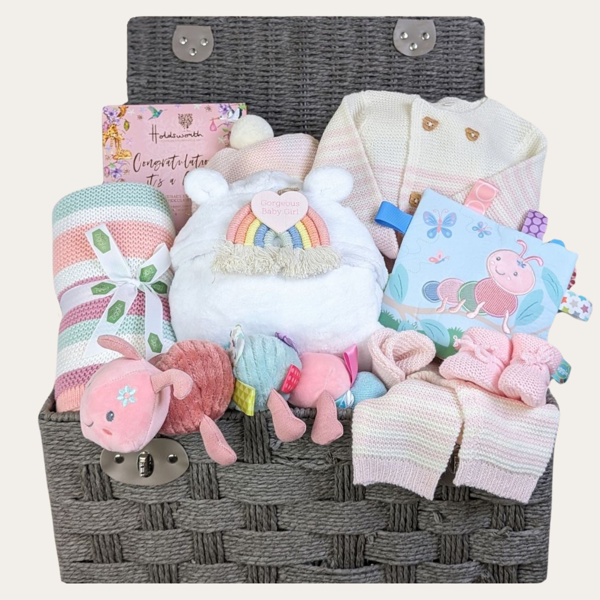 New baby girl gifts in a large hamper basket with pink striped baby clothes and blanket. Caterpillar themed baby toys and chocolate gifts for mummy.