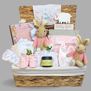 Baby girl gifts hamper with two flopsy bunnies in a large basket.