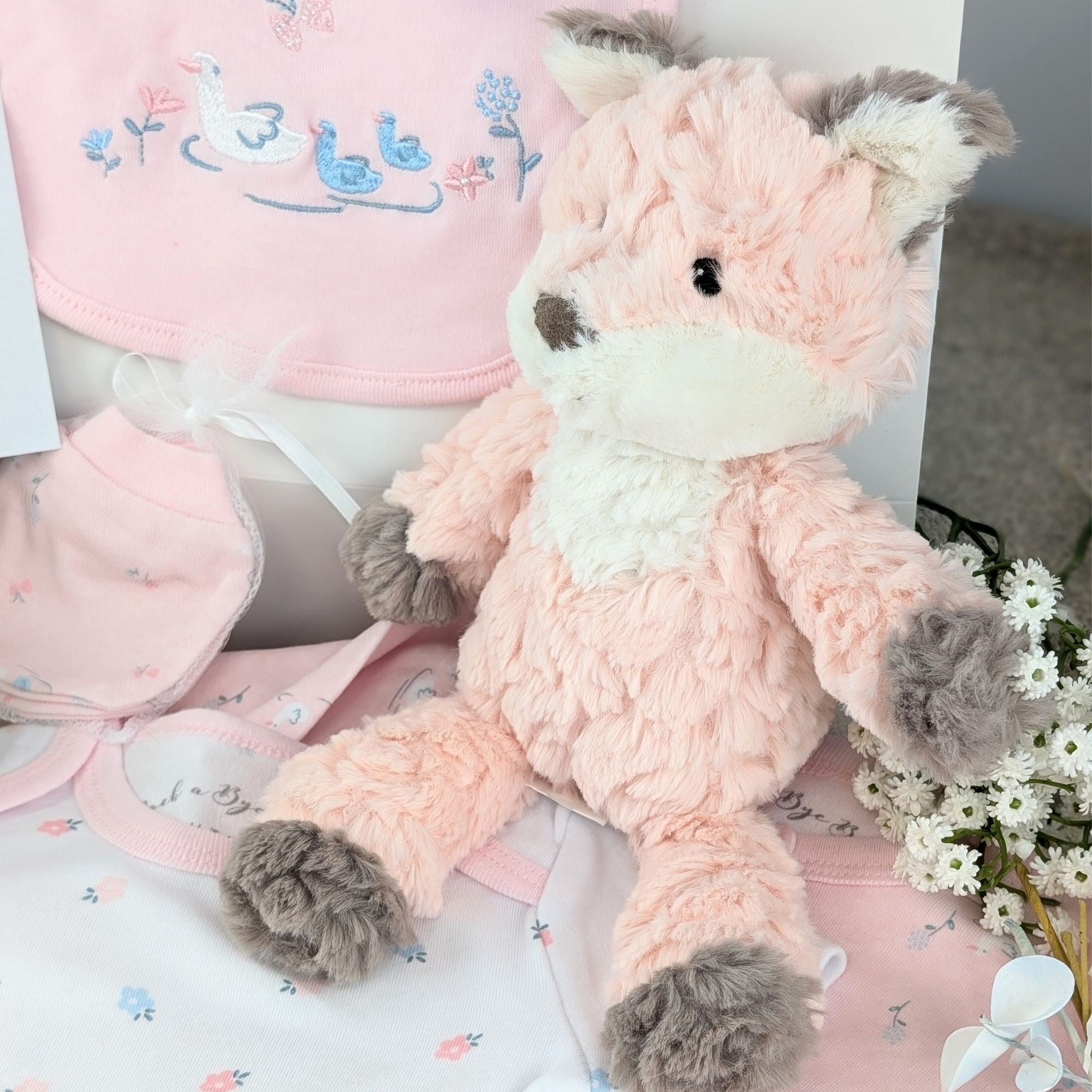 baby girl gifts hamper with little ducks and flowers on a baby clothing set and fluffy fox.