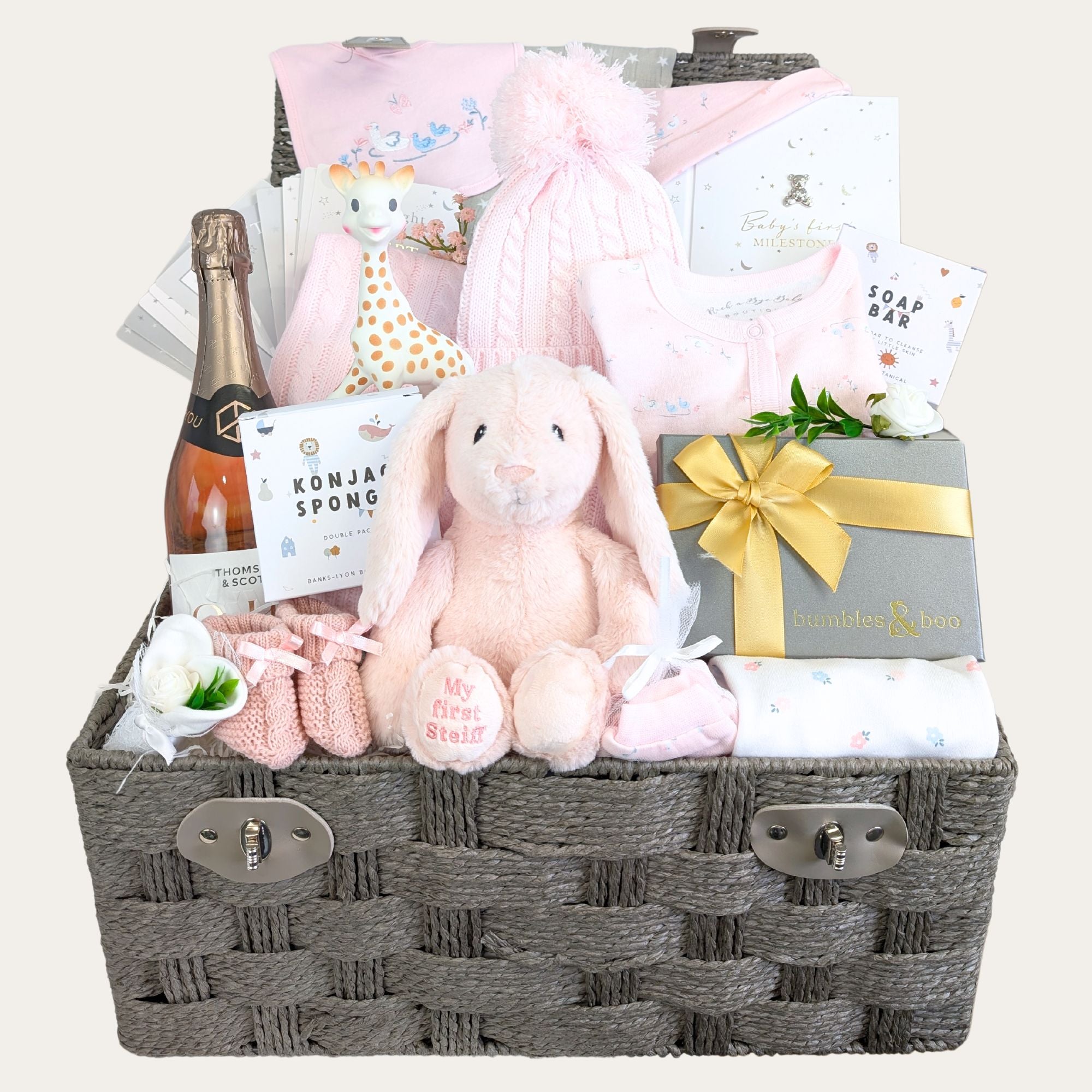 Baby girl gifts in a hamper basket with pink rabbit soft toy and clothes set.