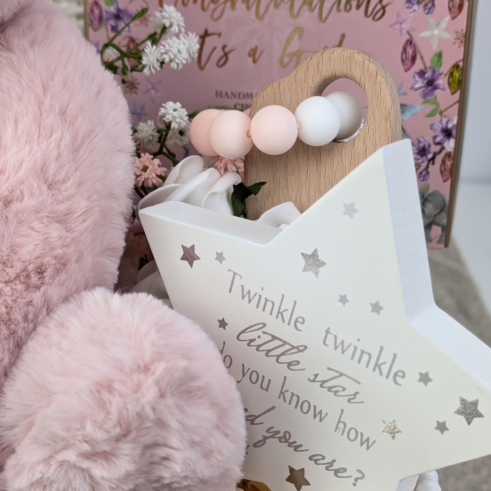 baby girl gifts hamper with large dusky pink teddy, chocolates, theething rings, nursery plaque, baby booties, hat and milestone cards.