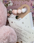 baby girl gifts hamper with large dusky pink teddy, chocolates, theething rings, nursery plaque, baby booties, hat and milestone cards.