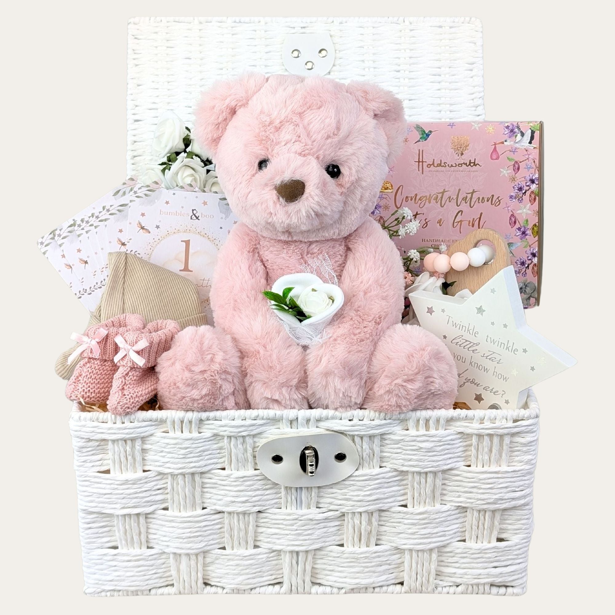 baby girl gifts hamper with large dusky pink teddy, chocolates, teething rings, nursery plaque, baby booties, hat and milestone cards.