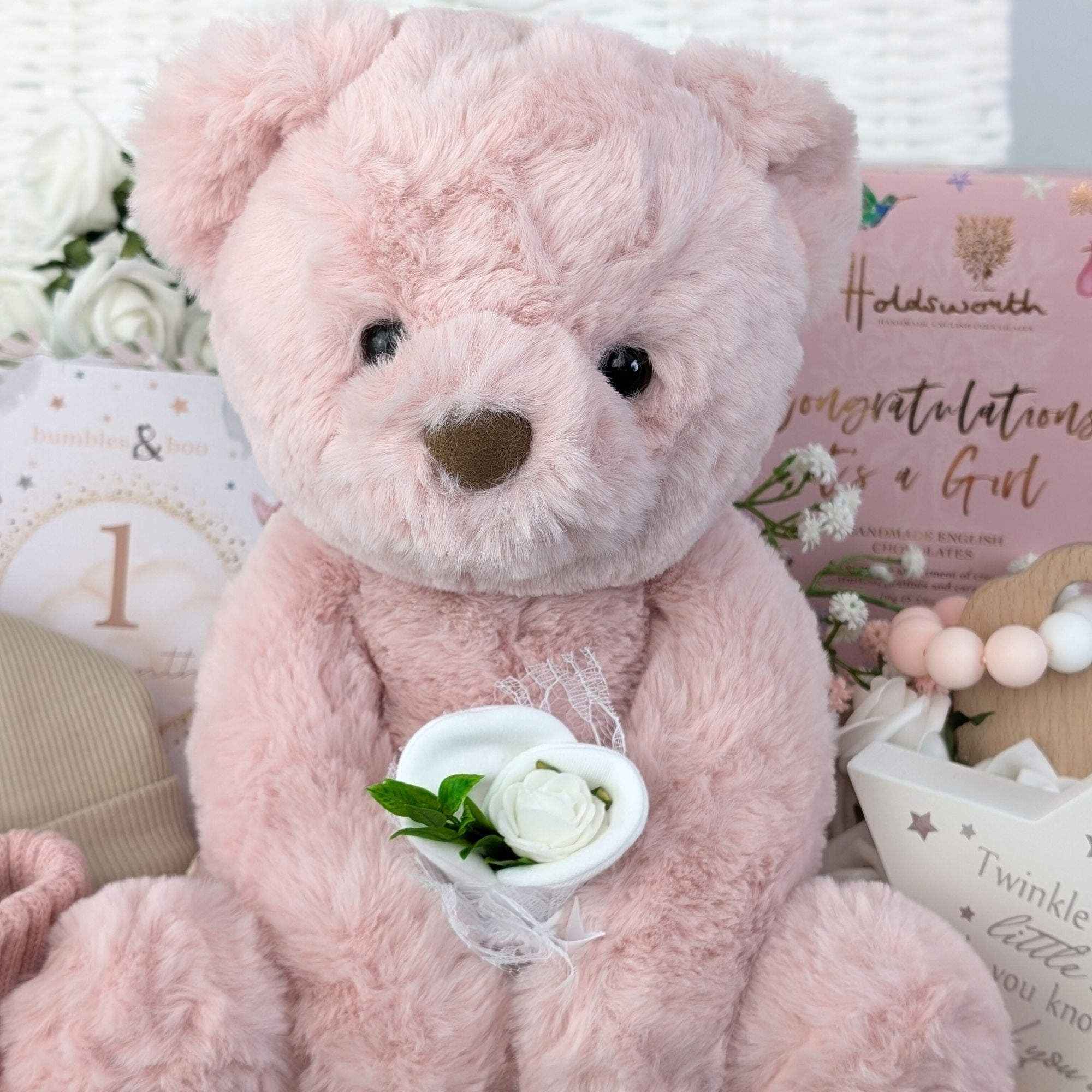 baby girl gifts hamper with large dusky pink teddy, chocolates, theething rings, nursery plaque, baby booties, hat and milestone cards.