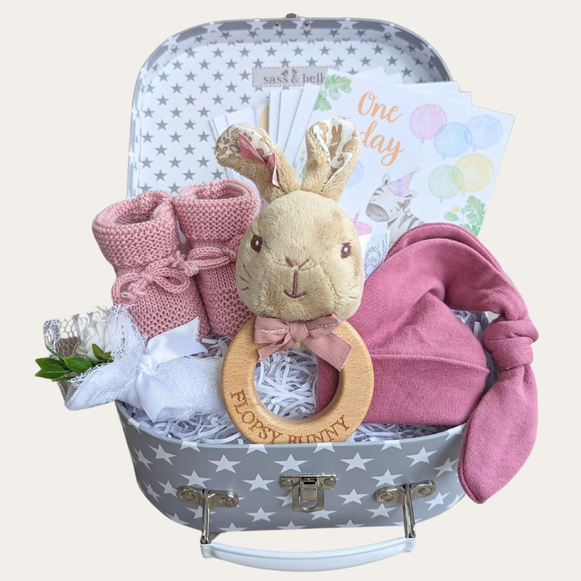 Newborn baby girl gifts hamper with flopsy bunny theme. Small grey stars gift box with dark pink hat & booties