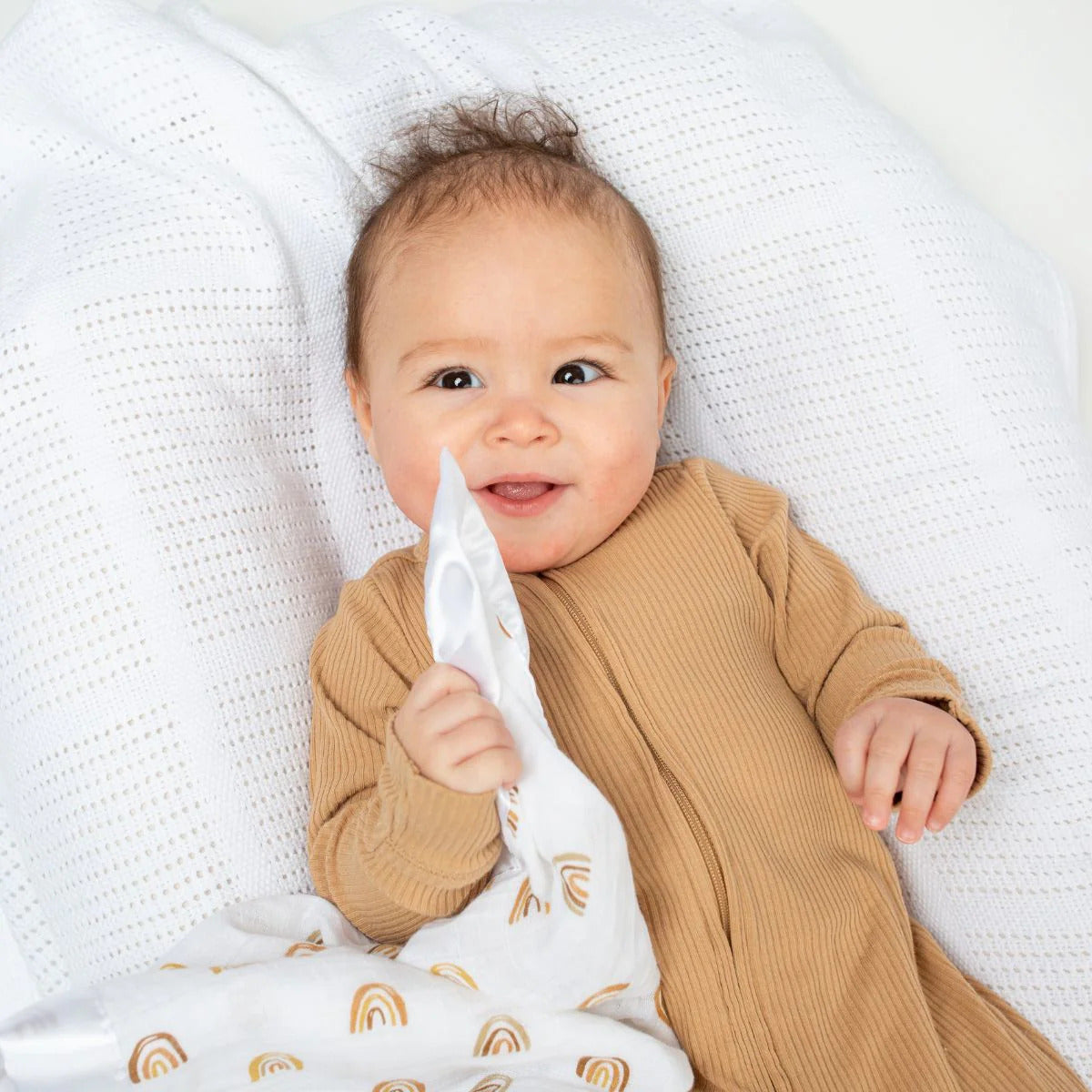 A set of two muslin security comforter blankets with a rainbow design and smooth satin edges