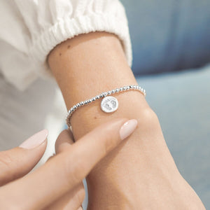 A silver beaded bracelet with a baby feet charm