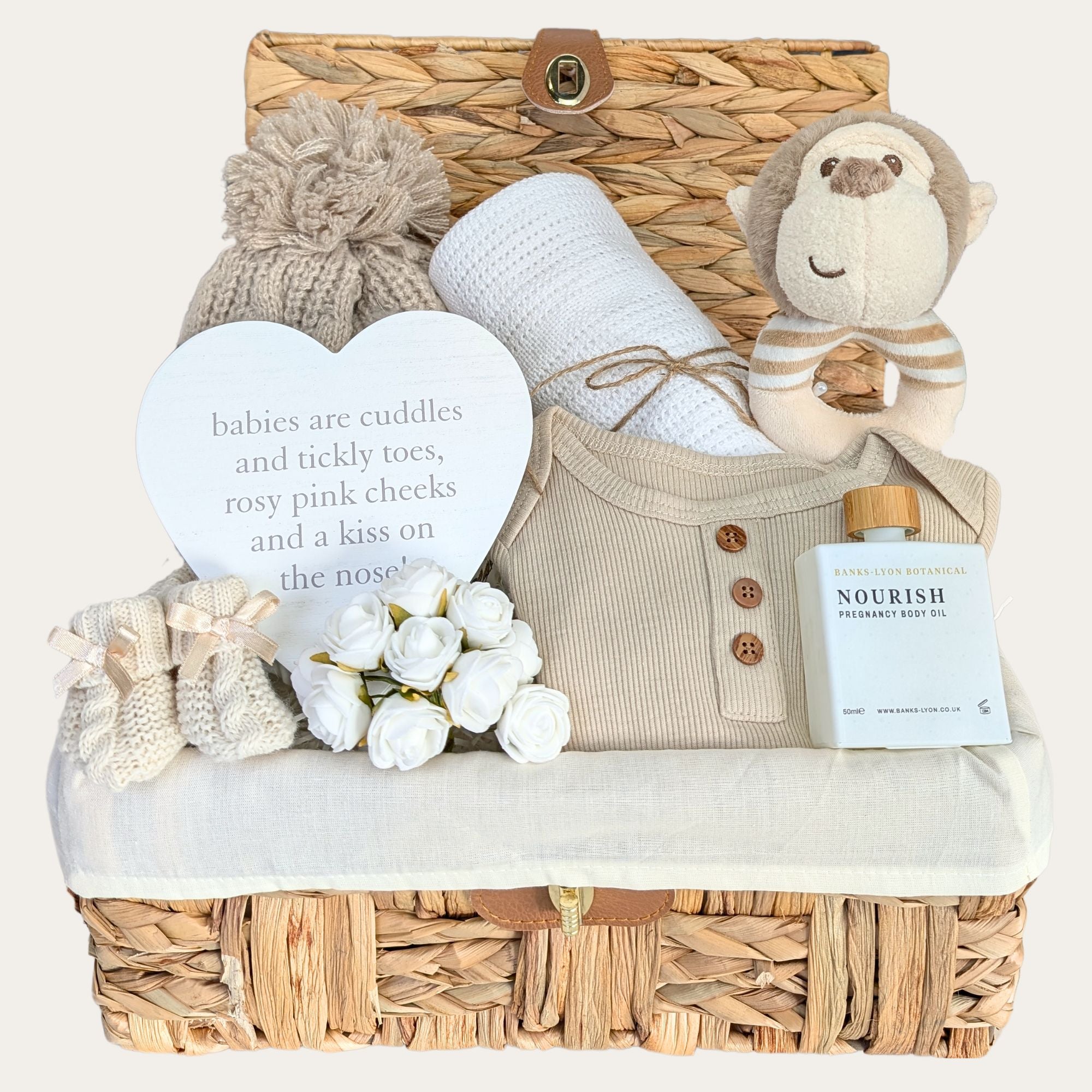 baby shower gift basket with white blanket, beige pompom hat, nursery plaque, organic skincare, monkey rattle and booties for baby. Bumbles and Boo.