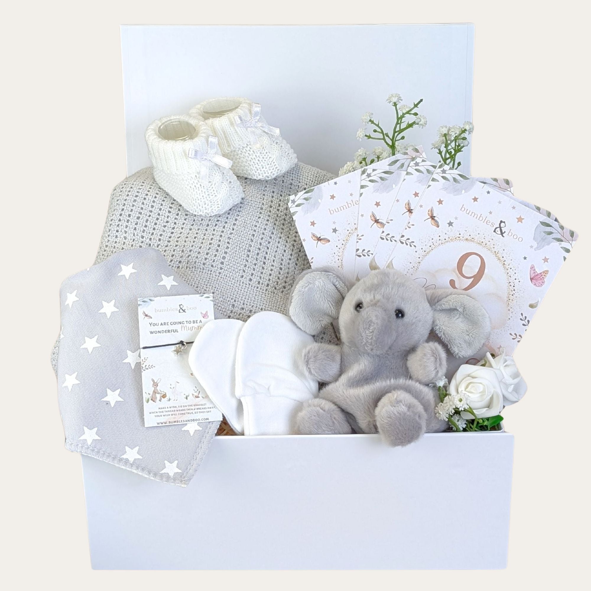 Baby shower hamper gifts packed in a white box with presents including grey cellular blanket, little ele soft toy and a gift for mum.