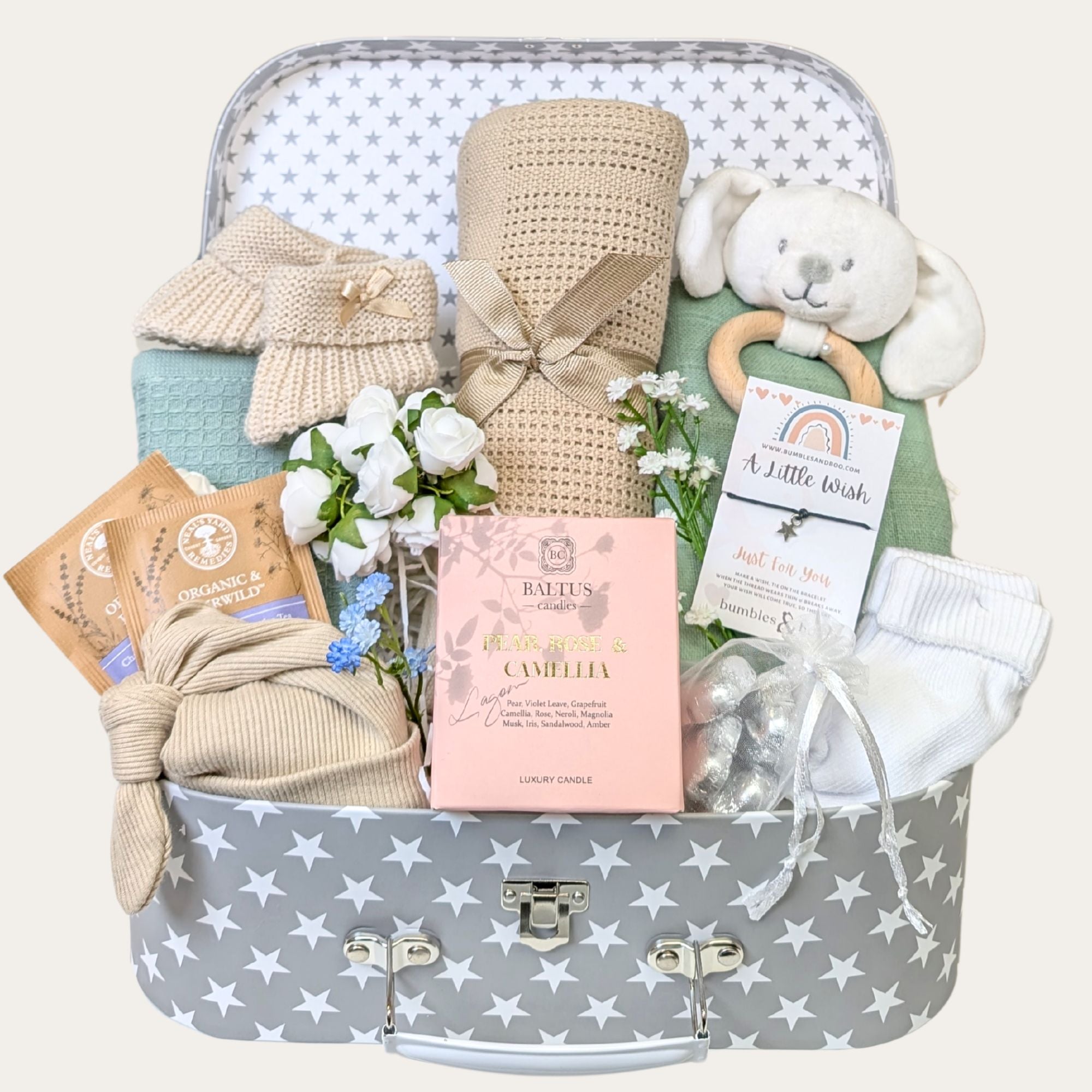 Baby Shower gifts hamper trunk featuring candle, baby blanket, booties, bunny rattle, socks, muslin, beige baby hat, chocolates and tea bags. 