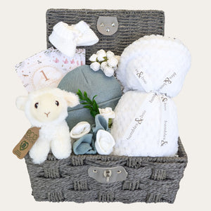 baby shower gifts hamper with white blanket, lamb soft toy, milestone cards, green hat and mittens and baby socks.