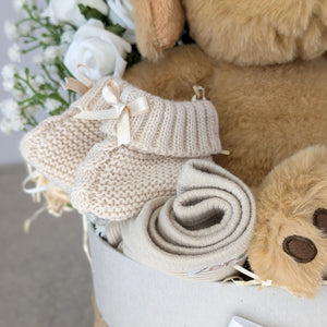 Close up of baby booties on the left side of the hamper.