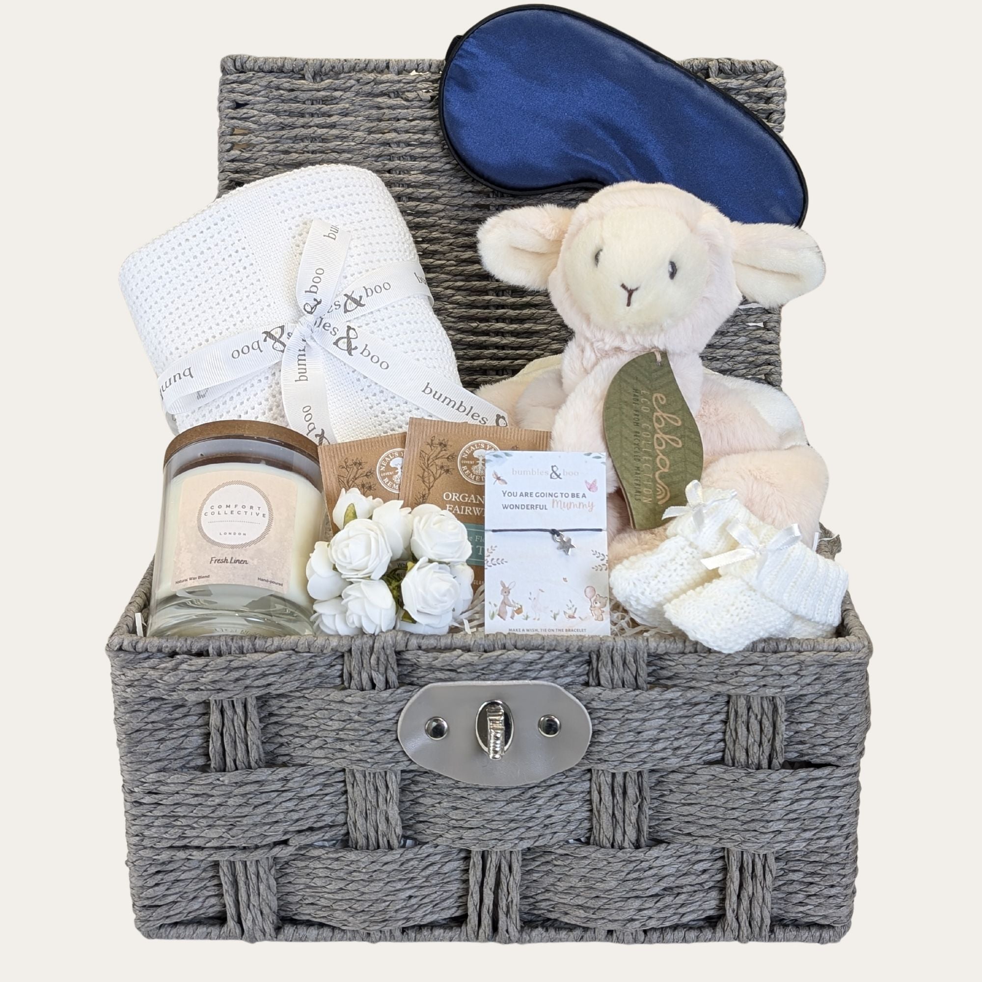 Baby shower gifts hamper in a grey wicker basket. Blue, white and grey colour theme.