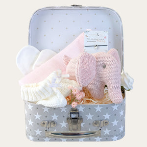 Baby shower gifts for girls with a pale pink elephant rattle in a little stars hamper trunk.