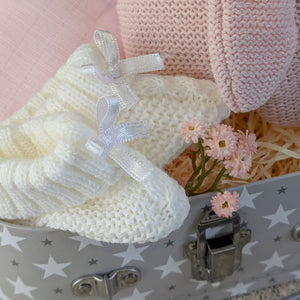 Close up of white baby booties.