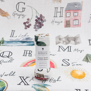 Tubed bamboo swaddle muslin blanket featuring an alphabet print. Crafted from a blend of bamboo and organic cotton, eco-friendly and perfect for sensitive skin.