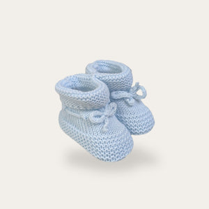 Blue knit baby booties with ties.