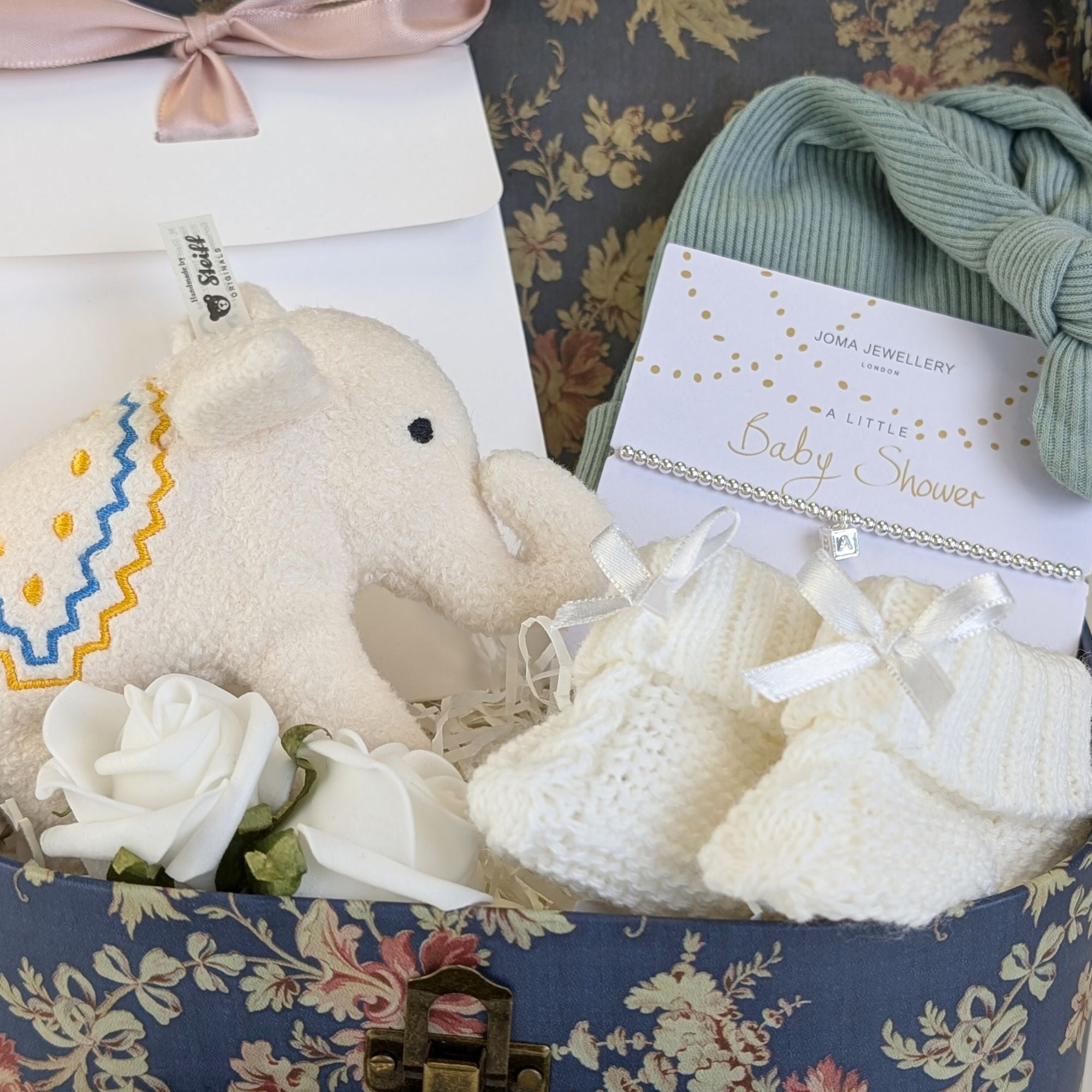 close up baby shower gift with bracelet and elephant.