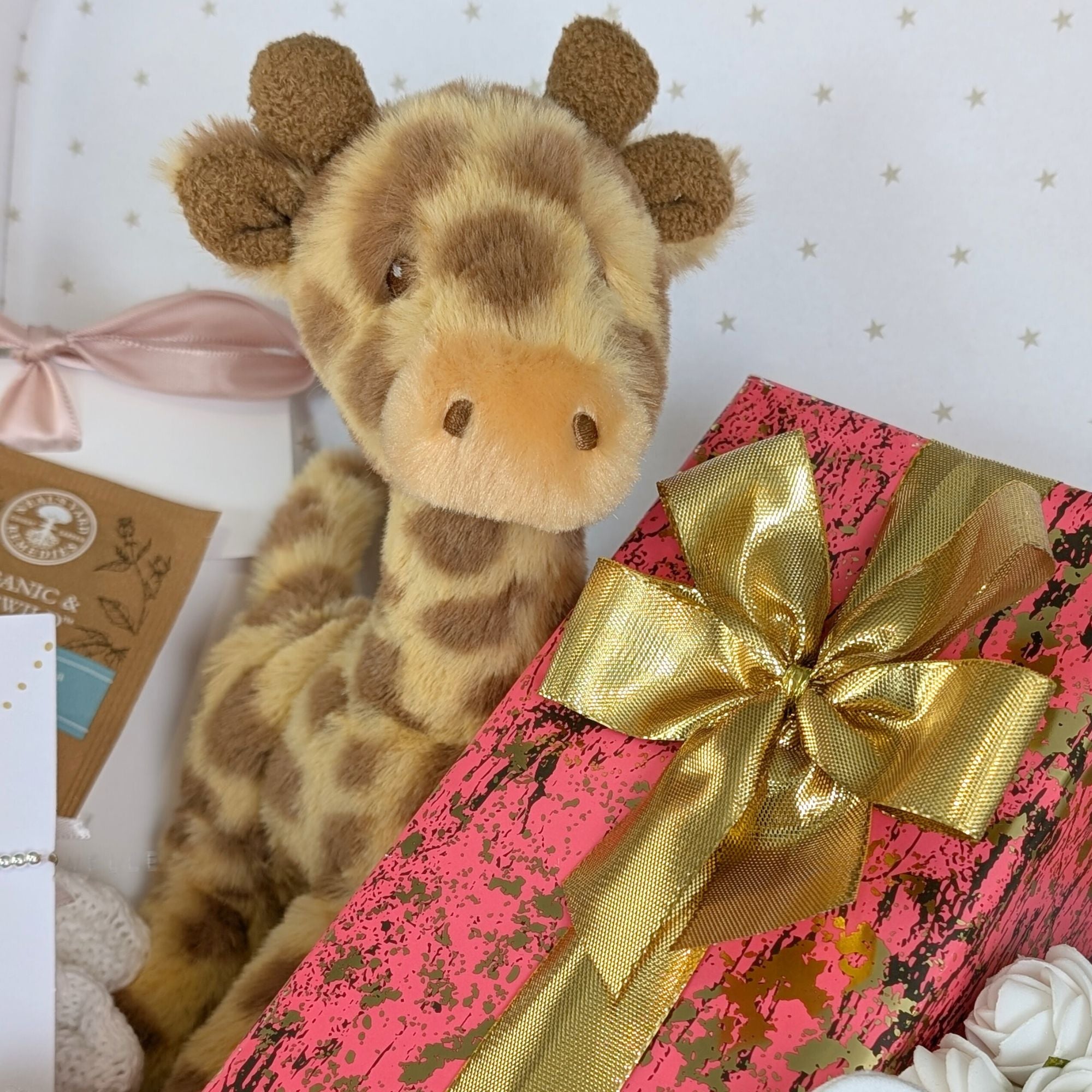 Close up of giraffe soft toy and chocolates.