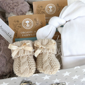 baby beige knit booties in a new mum luggage trunk