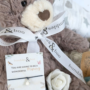 close up of a teddy bear and bracelet for a new mum