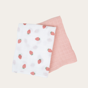 2 pack of large cotton muslin swaddle blankets in white with a strawberry print pattern and plain pink. 