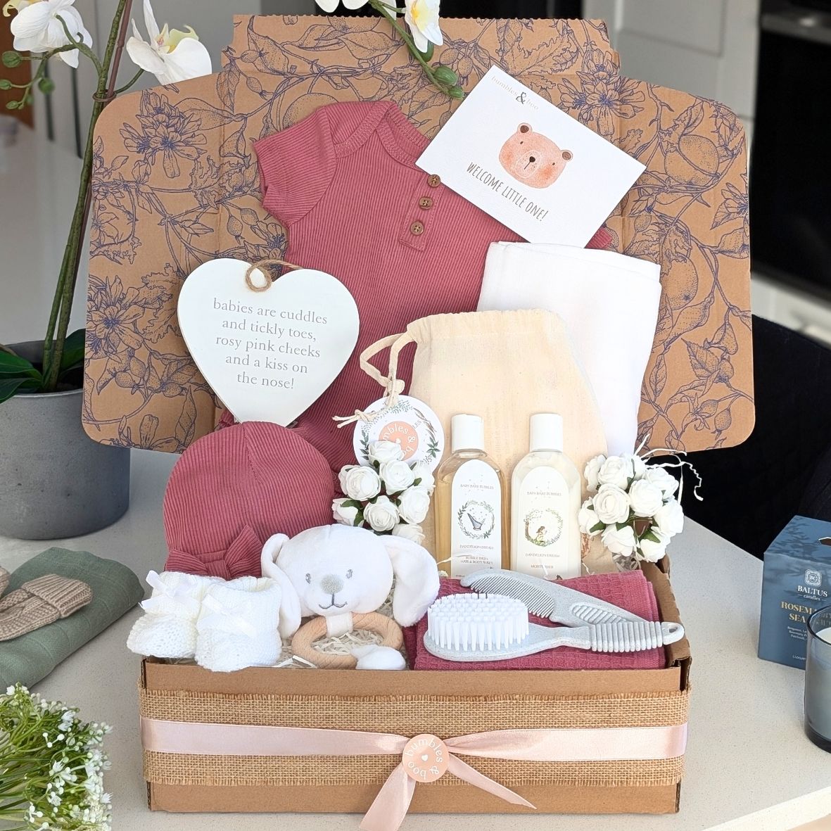 baby girl gift hamper with dusky pink clothing, organic skincare, brush and comb, baby booties and nursery plaque. Bumbles and Boo.