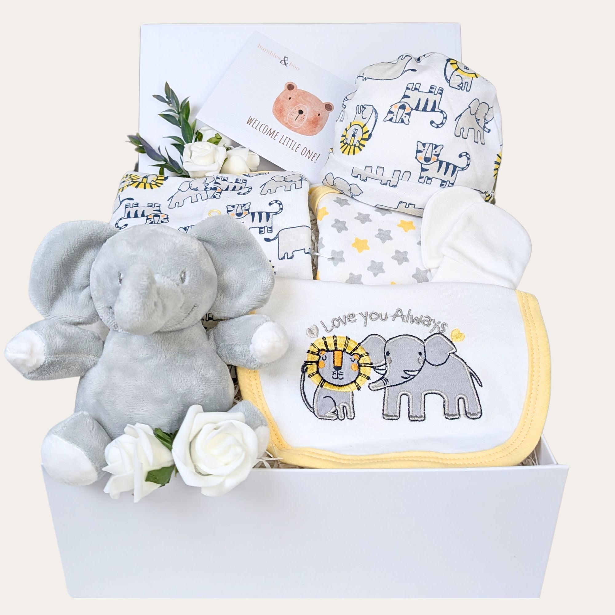 Baby shower gift box in white. This hamper contains a safari theme white and  yellow baby clothes set and a soft elephant toy.