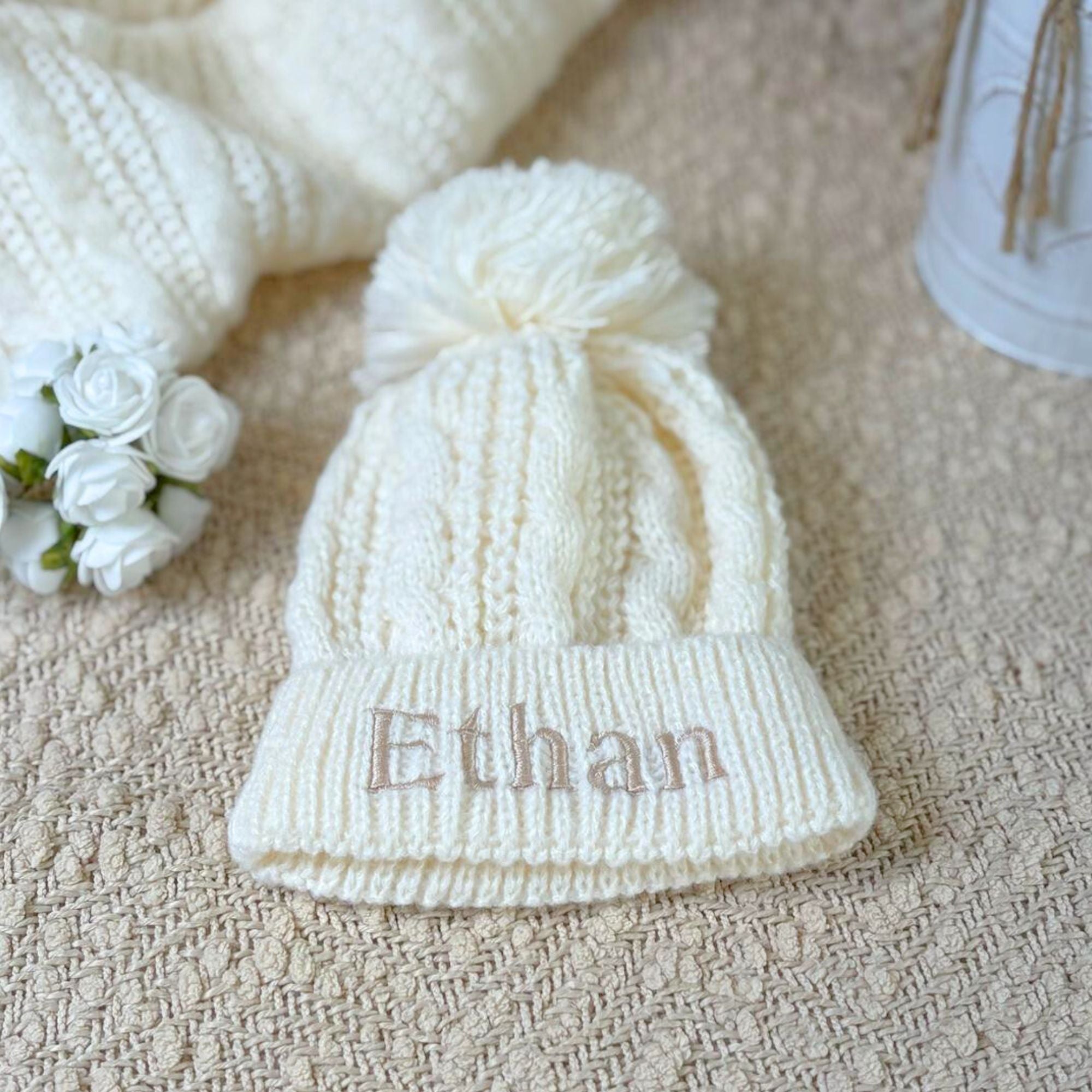 Cable knit cream bobble hat with champagne gold personalisation on brim of hat. Suitable from n-12 months. 