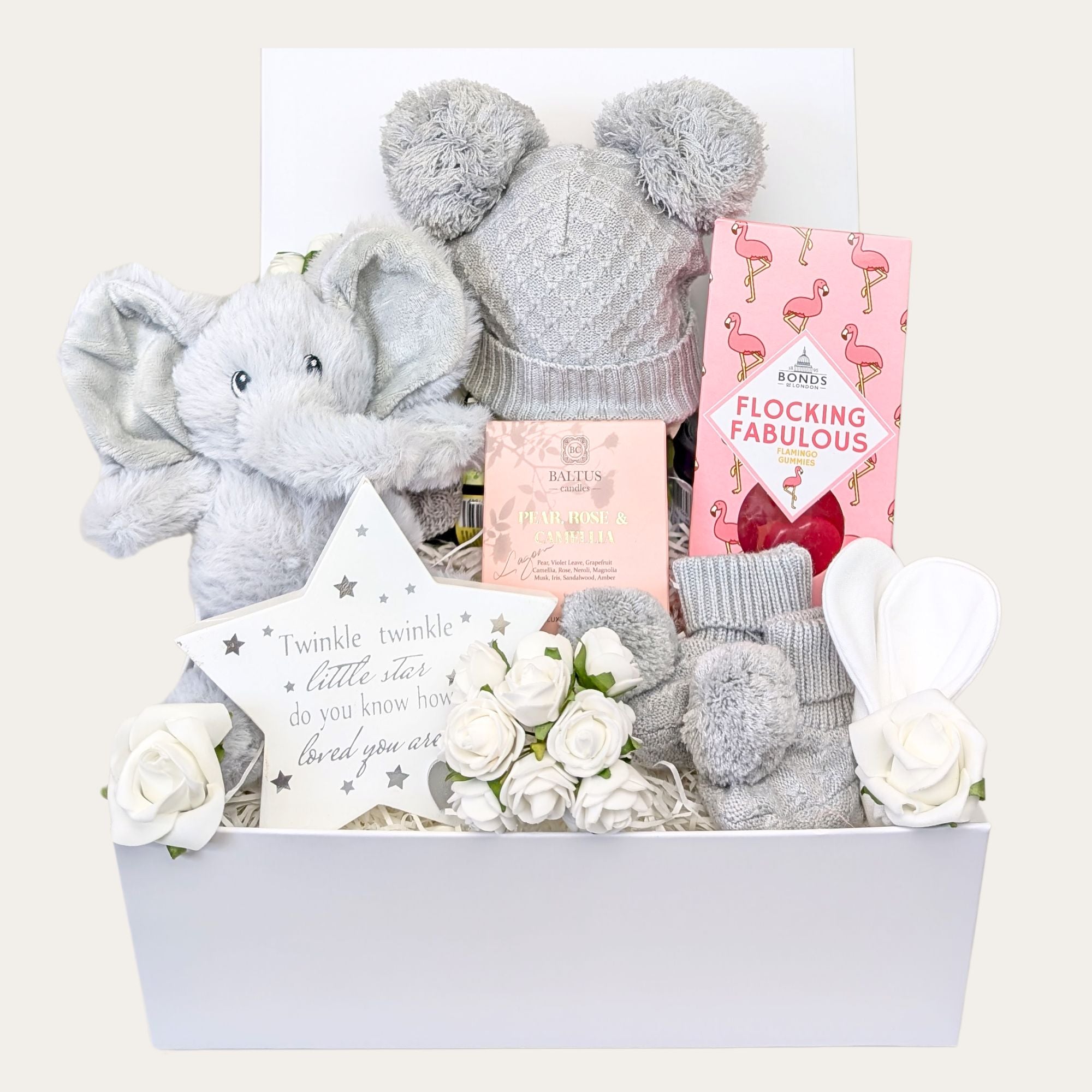 Matching knit pompom hat and booties set in choice of colours, cuddly elephant soft toy, white baby scratch mittens, nursery sentiment plaque, relaxation candle, and sweet treats for mum-to-be. Bumbles and boo