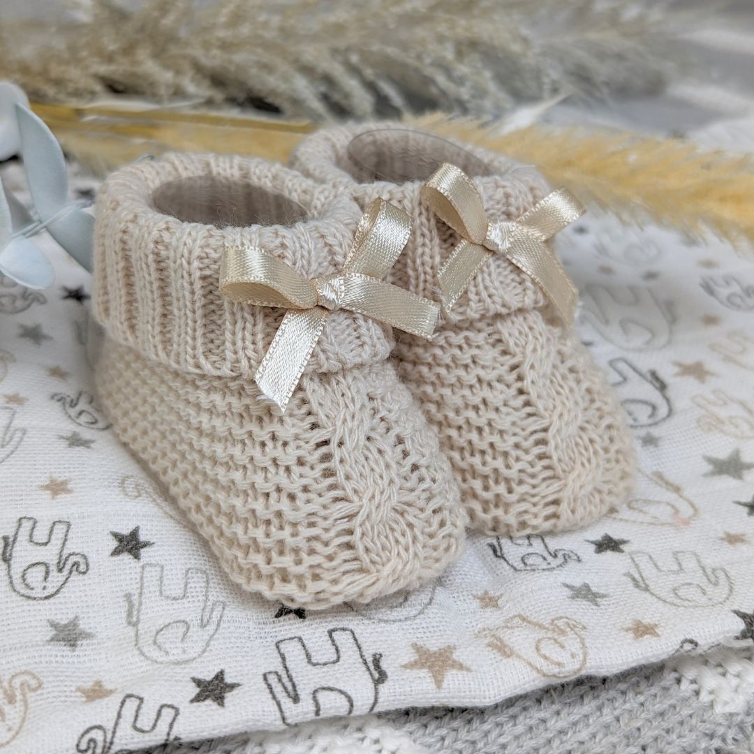 Soft booties with a tie bow in a taupe beige colour suitable for up to 3 months.