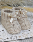 Soft booties with a tie bow in a taupe beige colour suitable for up to 3 months.